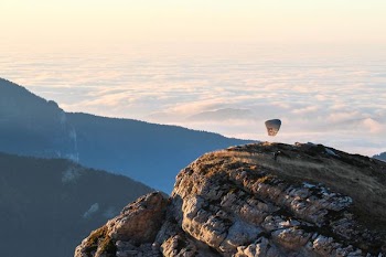 person riding parachute on mountain top