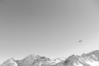 person riding parachute over snow covered mountain