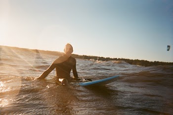 Person Riding Teal Surfboard