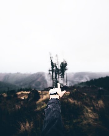 person's left hand pointing to castle