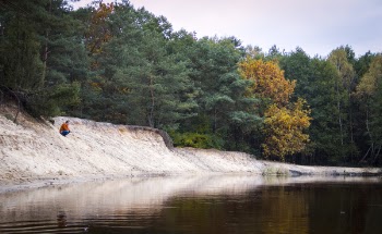 Person Seated Facing Body of Water