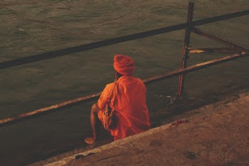 Person Seating Front of Calm Water