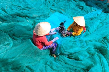 Person Sewing Blue Nets