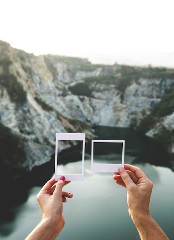 person showing hands near body of water during daytime
