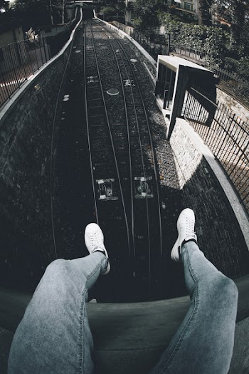Person Siting on Roof in Front of Train Railway
