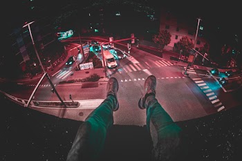 Person Sits on Building during Nighttime