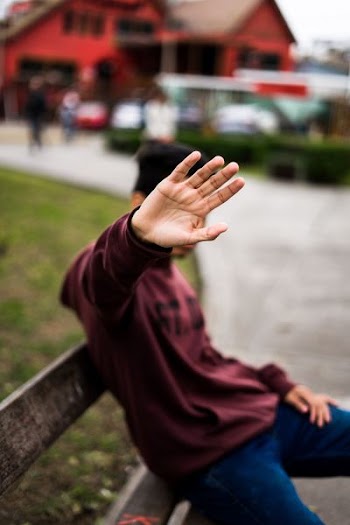 person sits on wooden bench