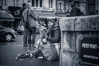 Person Sitting Behind Wall Grayscale Photo