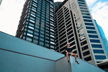 Person Sitting Beside Curtain Building