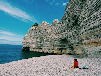 Person Sitting Beside Ocean Water