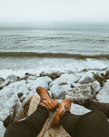 person sitting front of seashore