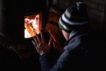 person sitting in front of burning woods