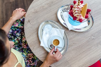 Person Sitting in Front of Wooden Table While Holding Teacup on Tray