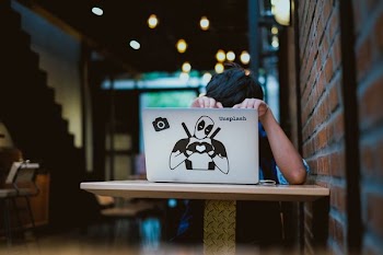 person sitting infront of table with laptop inside dim room