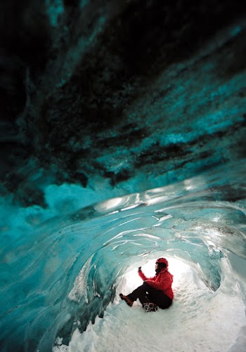 Person Sitting Inside Ice Cave