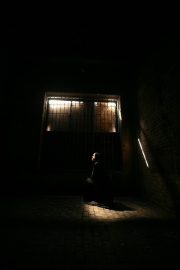 Person Sitting Near Brown Concrete Wall