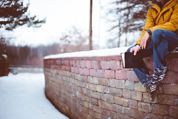 person sitting on brick wall