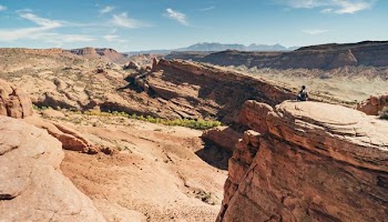 person sitting on brown mountain