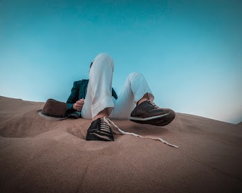 Person Sitting on Brown Sand