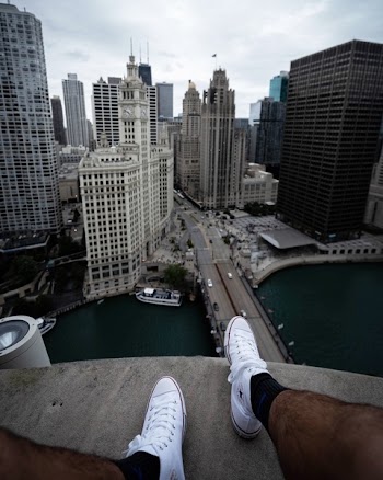 Person Sitting On Building Rooftop