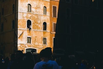 person sitting on building window