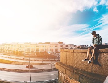 person sitting on edge of rooftop