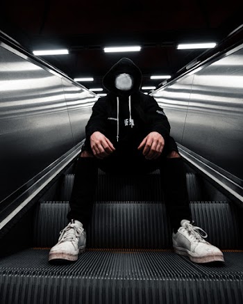 Person Sitting on Escalator