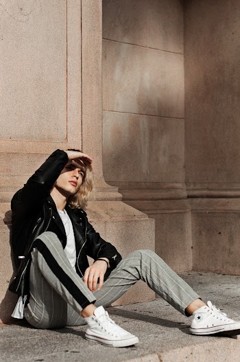 Person Sitting on Floor Wearing Black Leather Jacket