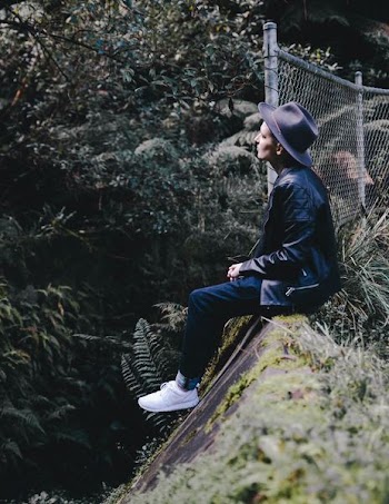 person sitting on gray concrete wall