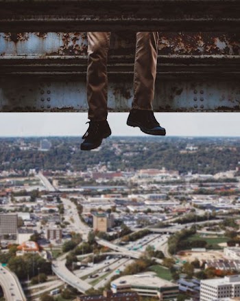 person sitting on metal above city