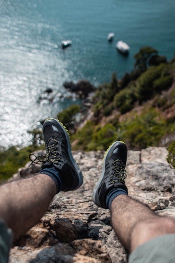 Person Sitting on Rock Near Cliff