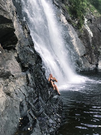 Person Sitting on Rock Near Water Falls