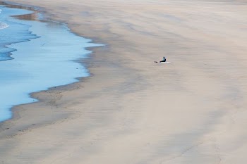 person sitting on seashore during daytime