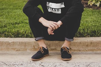 person sitting on sidewalk
