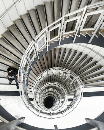 Person Sitting on Spiral Stairs