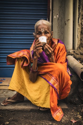 Person Sitting Outdoors Drinking