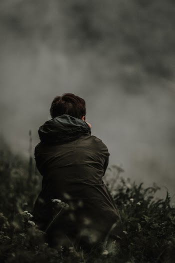 Person Sitting Surrounded by Plants