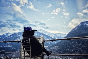 Person Sitting White Chair While Reading in Front-of Mountain Scenery