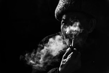 person smoking pipe grayscale photo