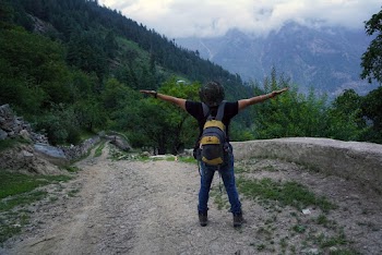 Person Standing and Raising Both Hands Near Mountain