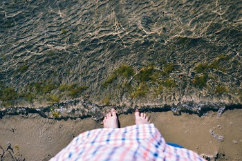 Person Standing Beside Clear Body of Water