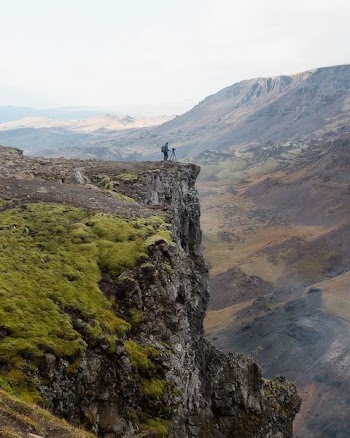 person standing beside cliff during daytime