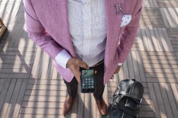 Person Standing Beside Duffel Bag While Using Smartphone