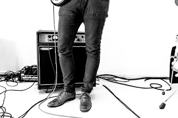 person standing beside guitar amplifier