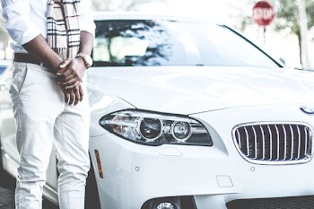 person standing beside the white BMW car