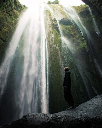 Person Standing Beside Waterfalls