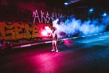 person standing holding flare in road
