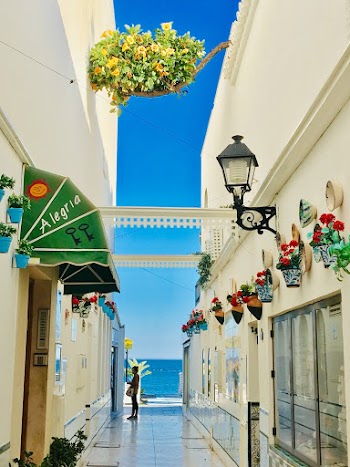 Person Standing in Between White Buildings