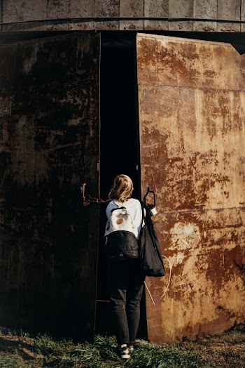 Person Standing In-front of a Rusty Door