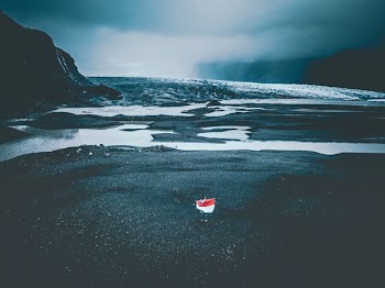 person standing in front of body of water during cloudy day